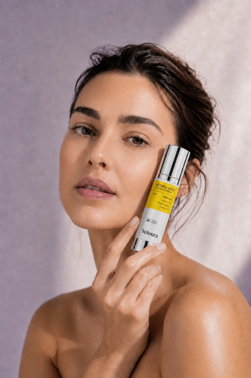 Modella con il Veloura Retinol Booster in mano